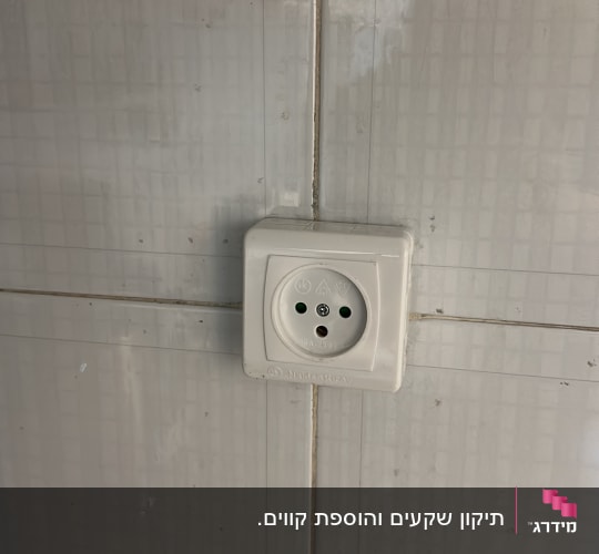 שקע חשמלי על קיר אריחים